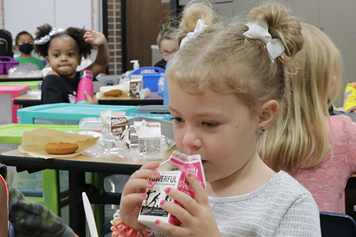 A student drinks milk during breakfast